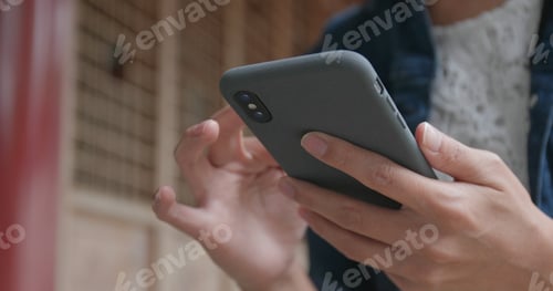 Preview: Close up of woman using mobile phone in Chinese garden