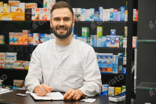 Preview: Pharmacist smiling and working at pharmacy counter