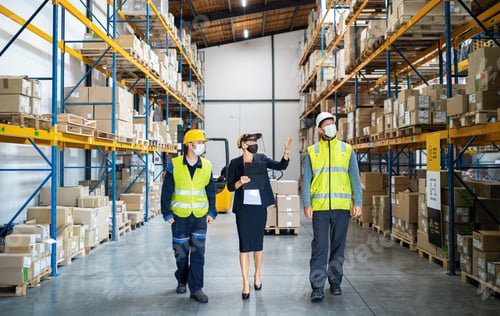 Preview: Group of workers with manager working indoors in warehouse, coronavirus concept.
