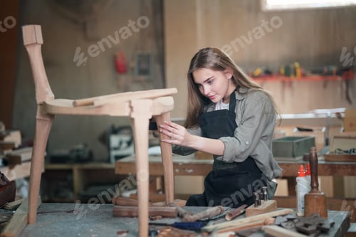 Preview: Young Woman Assembling Wooden Chair in Workshop