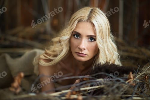 Preview: Woman with blonde hair lying near tree branches