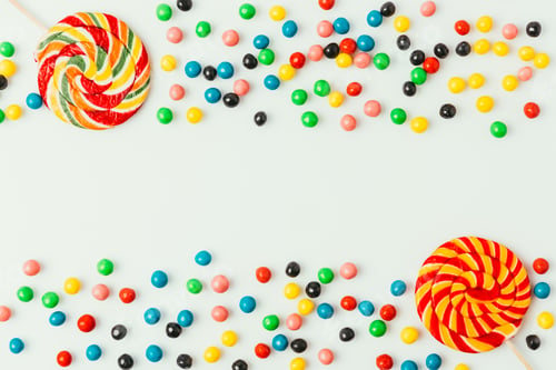 Preview: top view of arranged lollipops and candies isolated on white
