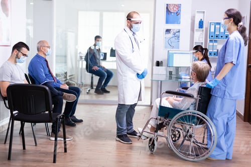 Preview: Young doctor talking with disabled woman