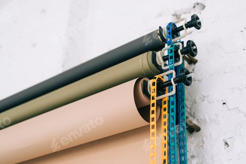 Preview: Paper backgrounds system on the wall in photo studio, close-up.