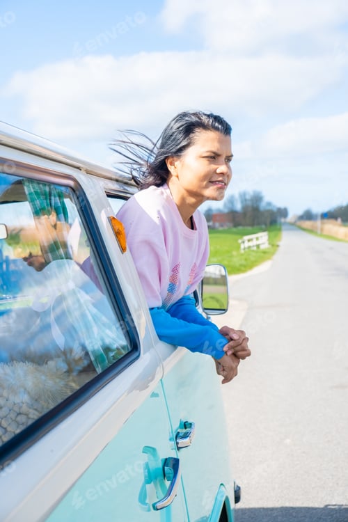 Preview: couple doing a road trip with an old vintage car in the Dutch flower bulb region with tulip fields