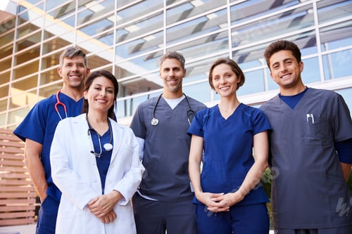 Preview: Five healthcare colleagues standing outdoors, group portrait