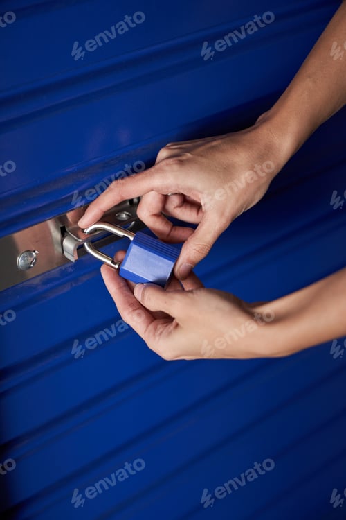 Preview: Nice woman's hands holding a blue padlock while closing it
