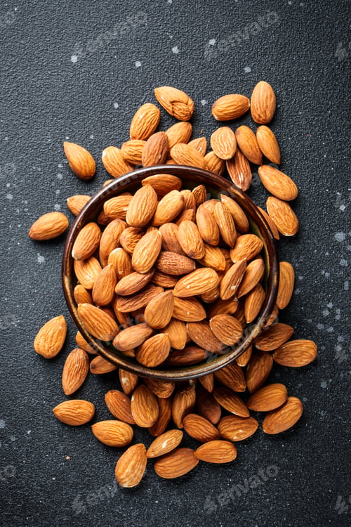 Preview: Almond nuts in bowl at black background.