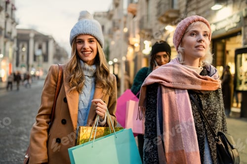 Preview: Cheerful women friends shopping winter city street fashion lifestyle bags evening urban scene