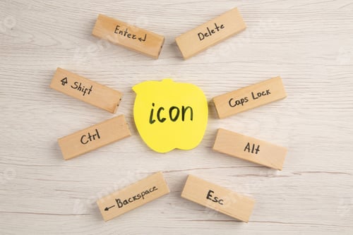 Vista previa: Vista superior de los iconos del teclado en bloques de madera icono escrito en una nota adhesiva amarilla sobre la mesa