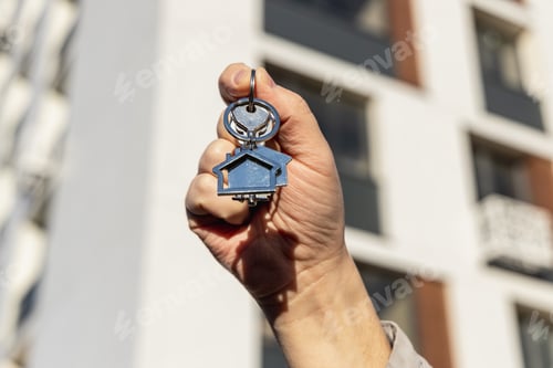 Preview: male hand holding house key,real estate agent.