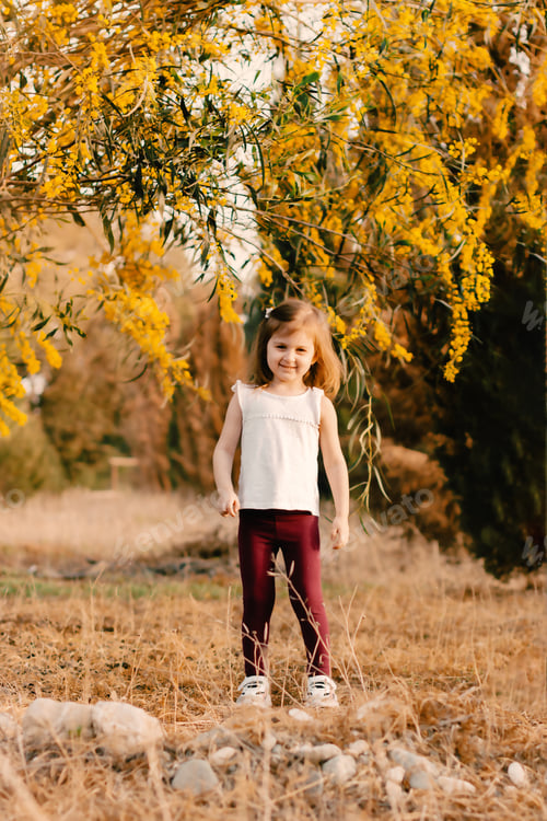 Preview: Toddler girl walking in spring park with blooming trees. Kids outdoor activities. Countryside life