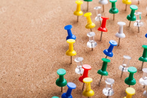 Preview: Group of thumbtacks pinned on corkboard