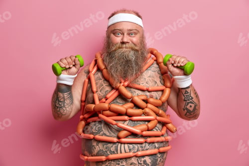 Preview: Glutton, junk food and sport concept. Naked bearded adult man with belly fat, wears headband and wri