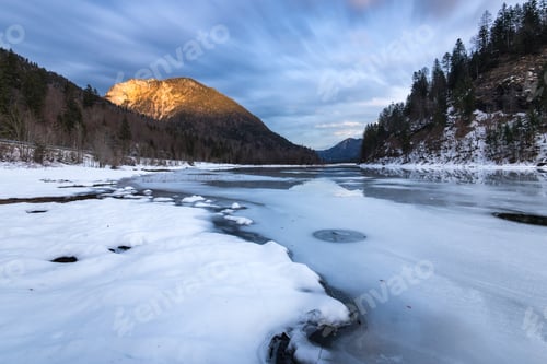 Preview: Frozen mountain lake in Bavaria Germany with glowing mountains in the background