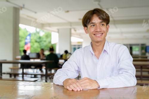 Preview: Non binary university student sitting in college campus
