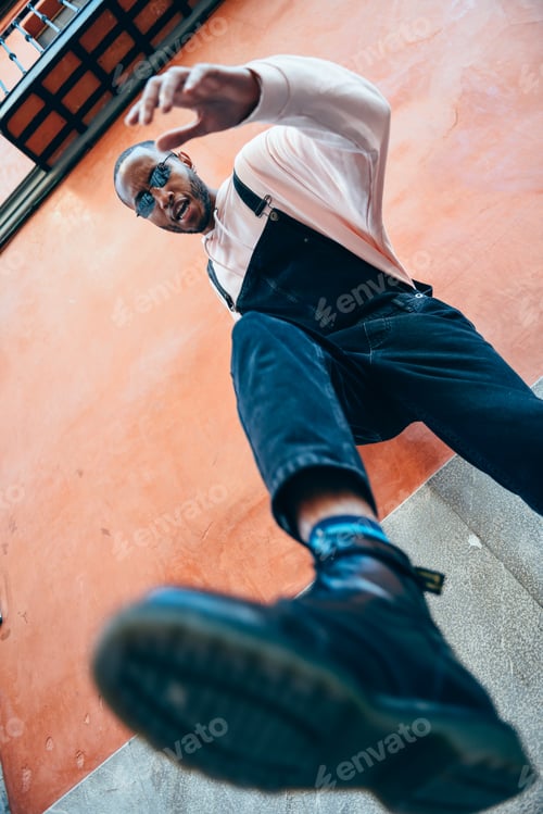 Preview: Young black man man kicking towards the ground.