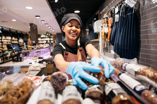 Preview: Butcher arranging sausages in supermarket display case