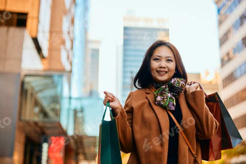 Preview: Happy Asian woman enjoying in shopping day and looking at camera.