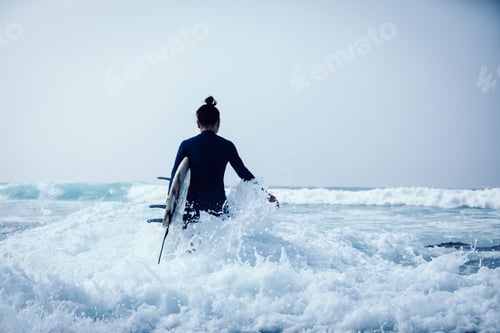 Preview: Surfer with surfboard in the waves