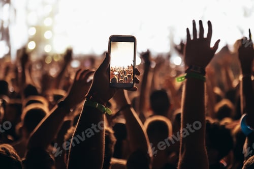 Preview: Silhouette of a woman using smartphone on a concert