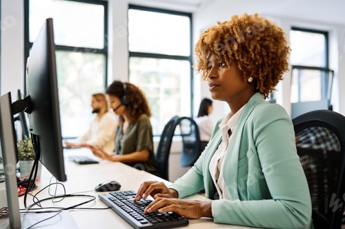 Preview: African woman using computer sitting on a coworking desk