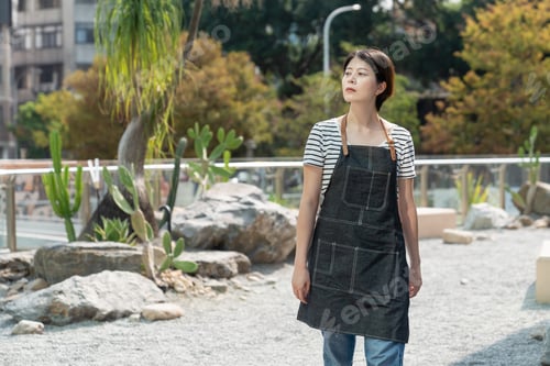 Preview: woman gardener looking into distance in the sun