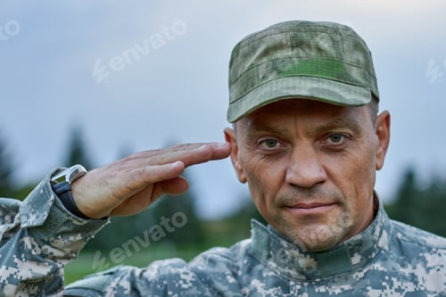 Preview: Close up portrait of serious soldier saluting.