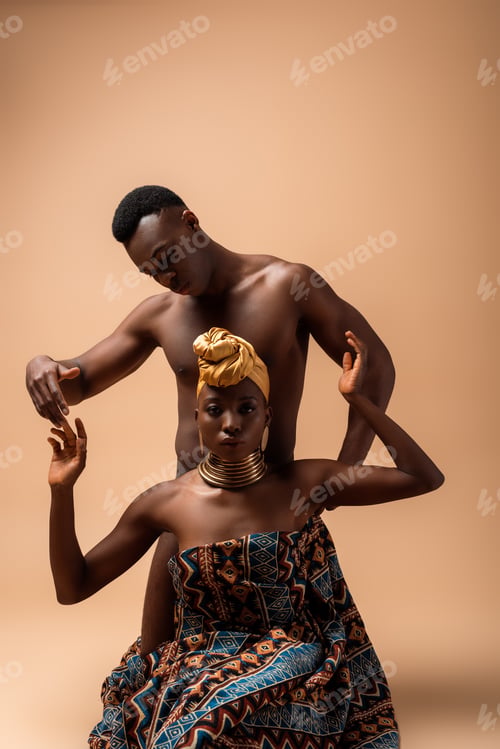 Preview: sexy naked tribal afro woman covered in blanket posing near man on beige