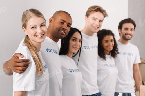 Preview: multiethnic group of volunteers standing in row and embracing