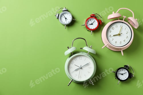 Preview: Different multicolor alarm clocks on green background