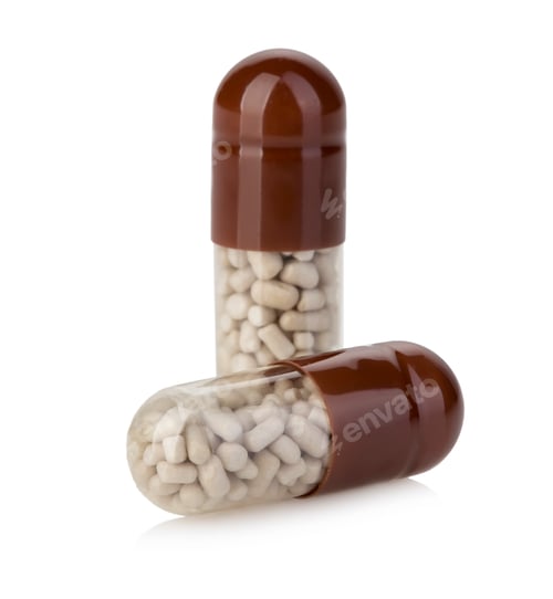 Preview: Brown capsules, pills close-up on a white background.
