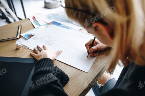 Preview: cropped shot of young fashion designer drawing sketch at workplace
