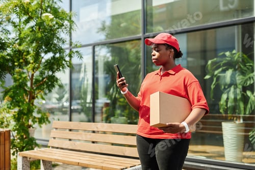 Preview: Delivering Worker Using Smartphone Wearing Red Uniform