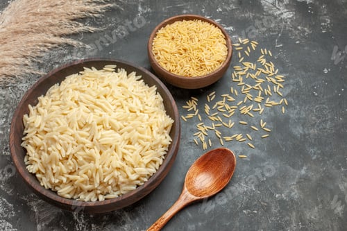 Preview: Front close view of rice meal and uncooked rice with spoon on dark background