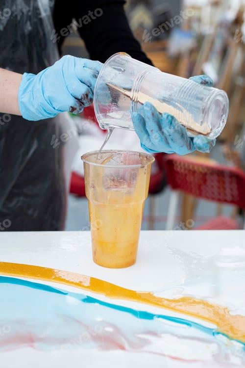 Preview: the artist mixes acrylic paints in a glass