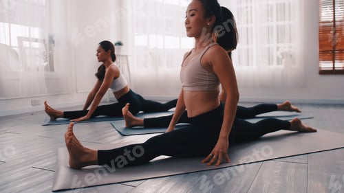 Preview: Group of Asian women stretching in yoga class. Group of girls doing Pilates exercises at the gym.