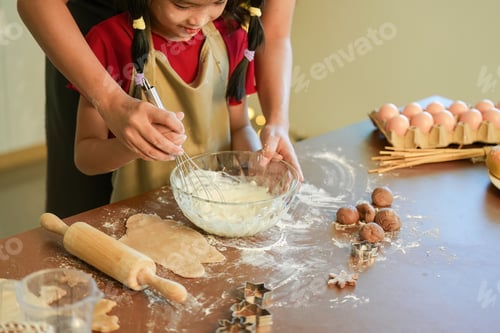 Preview: Creating Together A child and parent whisking batter for holiday cookies in a cozy kitchen