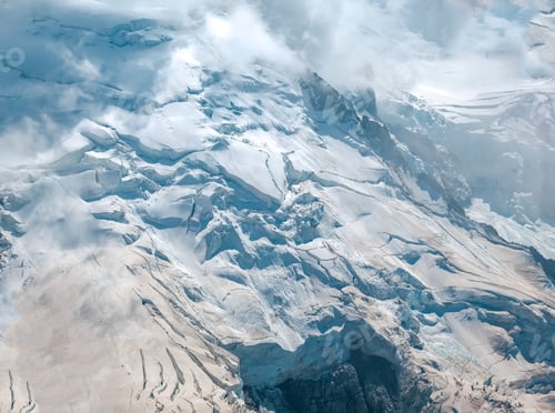 Preview: View of the Montblanc massif with its vertical glaciers at risk of avalanche, between the clouds.