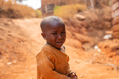 Preview: Portrait of a poor african child crying in the village, he wears dirty clothes.