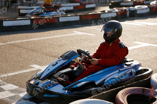 Preview: Racer in Red Suit Driving Go-Kart on Racetrack