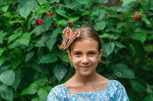 Visualização: Criança segura uma borboleta na mão. Hércules coscinocera. Foco seletivo.