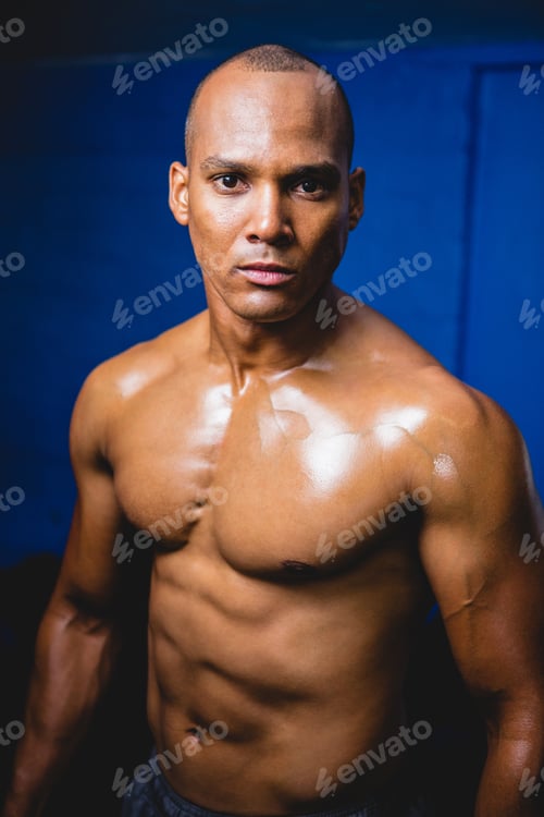 Preview: Portrait Of Unsmiling Male Athlete Against Wall In Gym