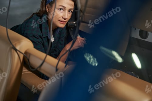 Preview: Seriously female mechanic working in salon of aircraft