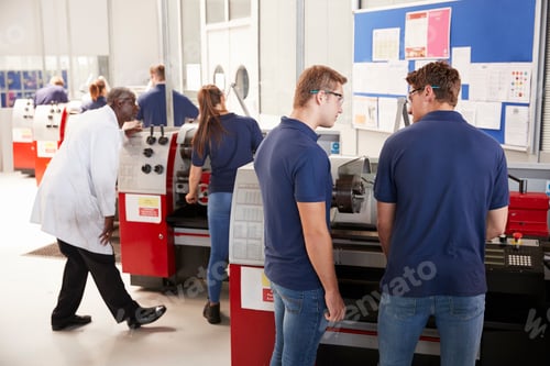Preview: Engineer giving guidance to apprentice in factory, close up