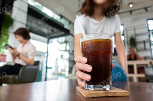Woman Holding Refreshing Iced Coffee in a Cafe