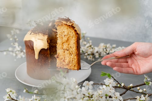 Preview: Hand holding piece of Easter cake on dessert spatula