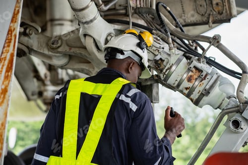 Preview: Aircraft maintenance engineer inspecting engine with safety gear and tools.