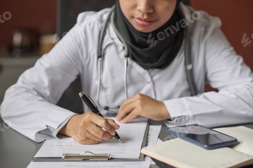 Preview: Young Female Physician Writing Information in Questionnaire