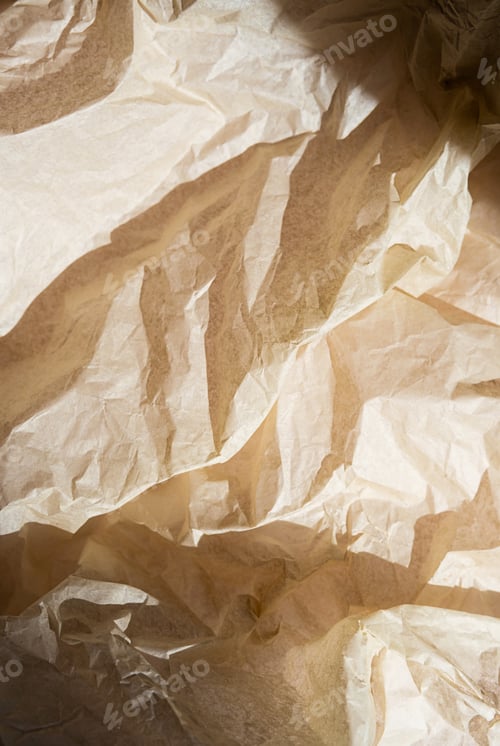 Preview: Crumpled beige paper texture with folds and creases.